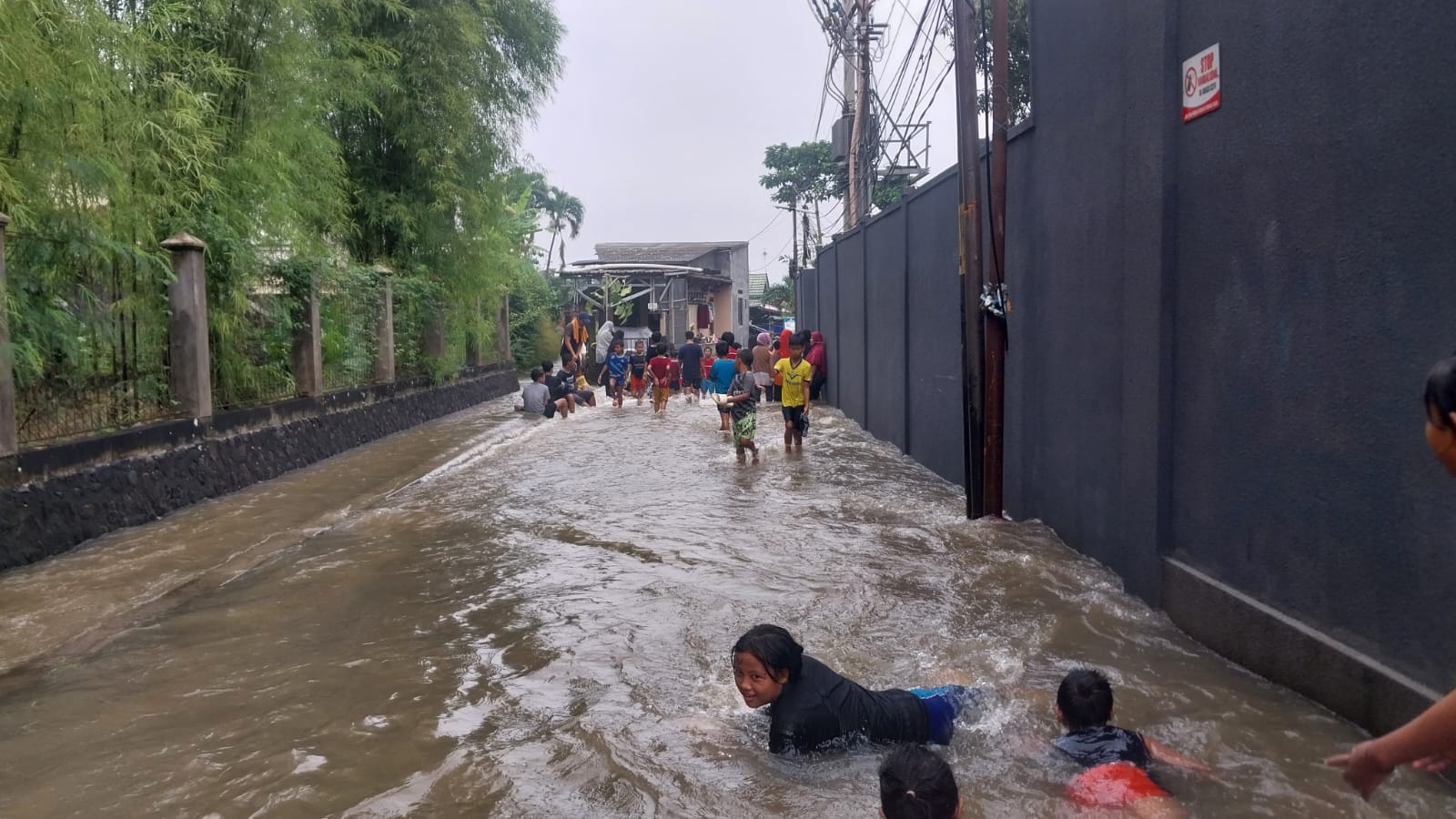 Belasan Anak Bermain dengan Banjir di Jalan Kampung Keramat