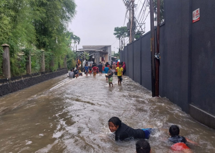 Belasan Anak Bermain dengan Banjir di Jalan Kampung Keramat